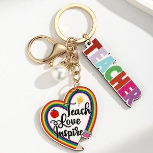 Detail of teacher keychain with heart charm, pearl and Teach Love Inspire message
