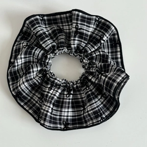Black and white checkered fabric scrunchie with delicate bow embroidery detail