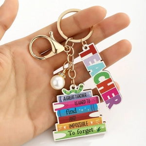 Detailed shot of wooden book charm keychain for teachers with motivational quote