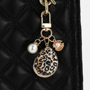 Detail of leopard print shell pendant with large pearl on black leather bag strap