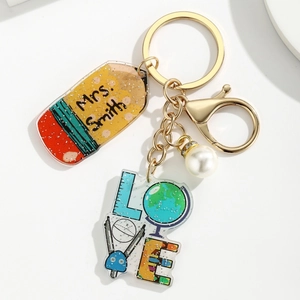 Detail of glittery acrylic apple keychain with personalized pencil and teacher love charms