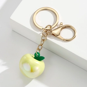Detailed close-up of translucent resin apple keychain with golden chain and lobster clasp