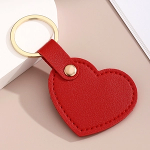 Vue détaillée du porte-clés coeur en cuir rouge avec anneau en métal doré