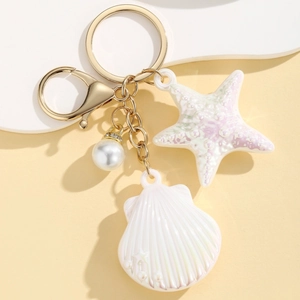 Detailed close-up of golden keychain featuring iridescent starfish and seashell charms