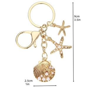 Golden ocean theme keychain with starfish and shell pendants featuring white pearls