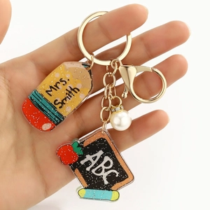 Close-up of personalized acrylic teacher keychain with pencil and blackboard pendants