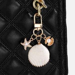 Detail of seashell keychain with starfish and pearl charms on black quilted bag