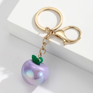 Detailed close-up of a purple iridescent apple resin keychain with golden metal clasp