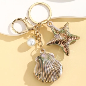 Detailed macro view of colorful sea star and shell charms with gold hardware and pearls
