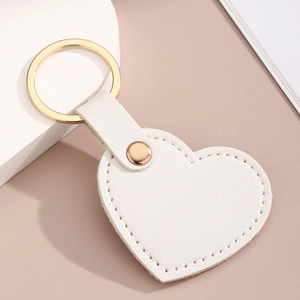 Détail du porte-clés cœur en PU blanc avec texture litchi et anneau doré