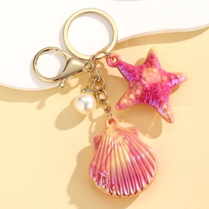 Close-up of ocean shell keychain with pink gradient starfish and white pearl charm