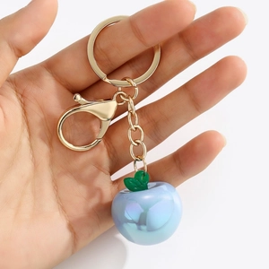 Detail of light blue pearlescent apple keychain with golden alloy lobster clasp and ring