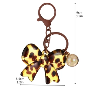 Leopard print acrylic bow keychain with brown metal clasp and holographic bead charm