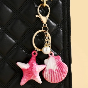 Detail of colorful resin starfish and seashell pendant on a quilted leather bag