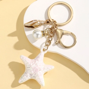 Detailed view of colorful resin starfish keychain with sea snail and pearl charm