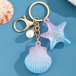 Détail du porte-clés coquillage en acrylique avec anneau doré et pendentif étoile