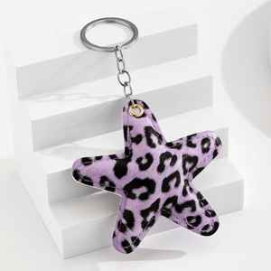 Detail of star-shaped purple leopard print leather keychain on geometric display base