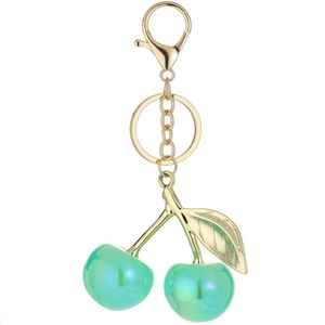 Green cherry keychain with golden leaf and lobster clasp on a white background