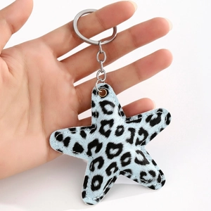 Leopard print star leather keychain with blue fabric and silver metal clasp held in hand