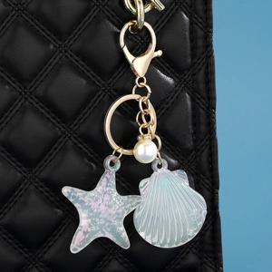 Porte-clés océan en acrylique avec étoile de mer, coquillage irisé et perle sur sac