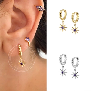 Detail of star pendant hoop earrings with purple zircon in gold and silver finishes