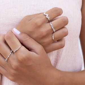 Close-up of minimalist silver rings with rectangular and round cubic zirconia stones