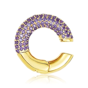 Detailed macro view of C-shaped ear cuff with purple pave-set stones and gold-plated finish
