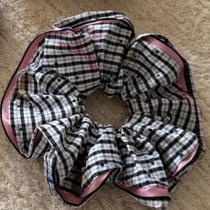 Detail of oversized scrunchie with black and white gingham pattern and pink satin trim