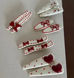 Detail view of red bow and polka dot hair clips set in cream resin finish