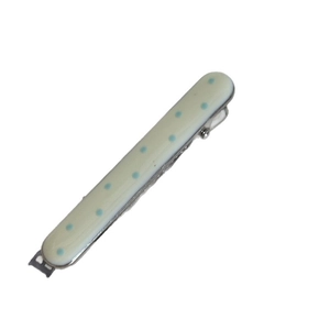 Barrette à cheveux minimaliste crème à pois bleus présentée sous un angle oblique