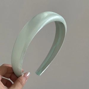 Detail of light green satin padded headband with premium silky texture and sponge volume