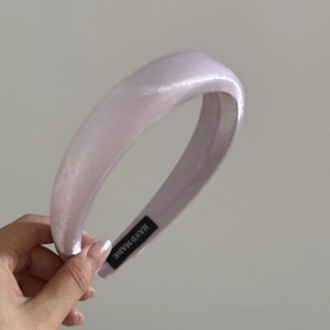 Detailed macro view of handmade light purple satin headband with luxury silk texture