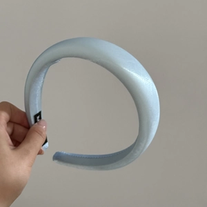 Macro shot of light blue satin sponge headband with elegant thick padded design