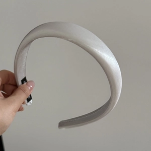 Close-up of a premium grey satin padded headband with a smooth silk-like texture and soft sponge fill