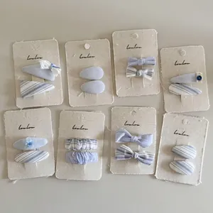 Set di otto fermagli per capelli in tessuto azzurro e a righe con pizzo e fiori