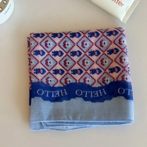 Detail of blue plaid square scarf with cartoon prints and white HELLO text on the border