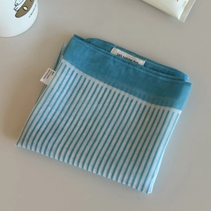Detail of blue plaid checkered cotton headscarf showing neat edges and fabric texture