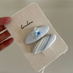 Set di fermagli per capelli a righe blu menta e fiori in rete per bambine su carta