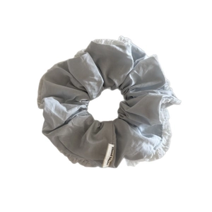 Handmade light blue scrunchie with white lace edges and a woven hand made tag