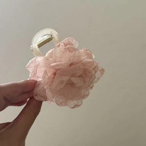 Detail showing layers of light pink chiffon flower hair claw clip with golden spring