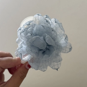 Close-up of light blue chiffon flower hair claw clip with soft layered petal texture