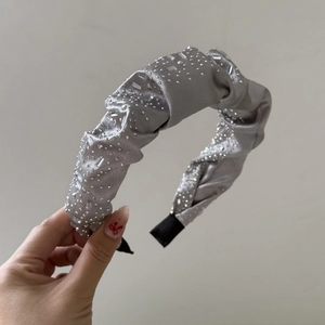 Detailed macro shot of grey silk padded headband decorated with sparkling rhinestones