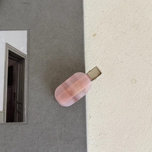 French style pink acetate hair clip with silver metal clamp on a textured background