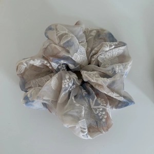 Detail of embroidered floral organza scrunchie with layered fabric and stitching