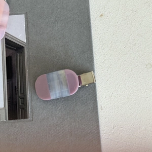 Close-up of pink and grey striped acetate hair clip with silver metal alligator grip