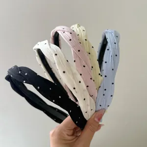 Primo piano di cinque cerchietti a pois colorati in nero, rosa, blu, giallo e bianco