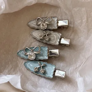 Silbergraue und blaue Strass-Haarspangen mit Kirsch-Schleifen-Motiv auf Papier