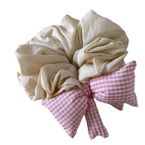Chic cream oversized scrunchie with a pink gingham bow design for elegant hair styling