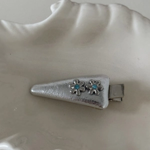 Dettaglio del fermaglio per capelli in pelle argento con fiori in cristallo blu