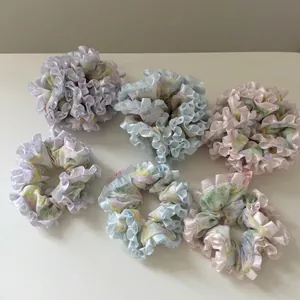 Set of six floral ruffle hair scrunchies in pastel macaron colors with ribbon trim edge